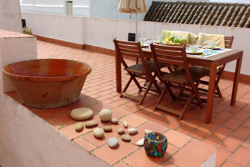 un patio con mesa, sillas y huevos en el suelo en Albayalde Cielo y Mar en Vejer de la Frontera