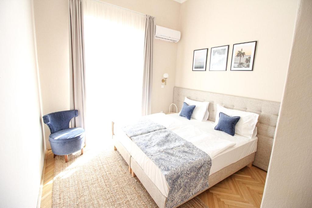 um quarto com uma cama e uma cadeira azul em Platán em Siófok