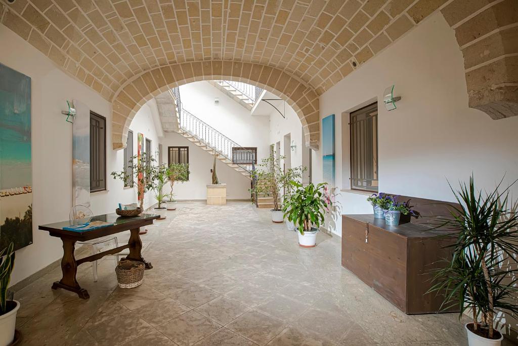 un couloir avec des plantes en pot dans un bâtiment dans l'établissement CasaTrapani Rooms & Apartments, à Trapani