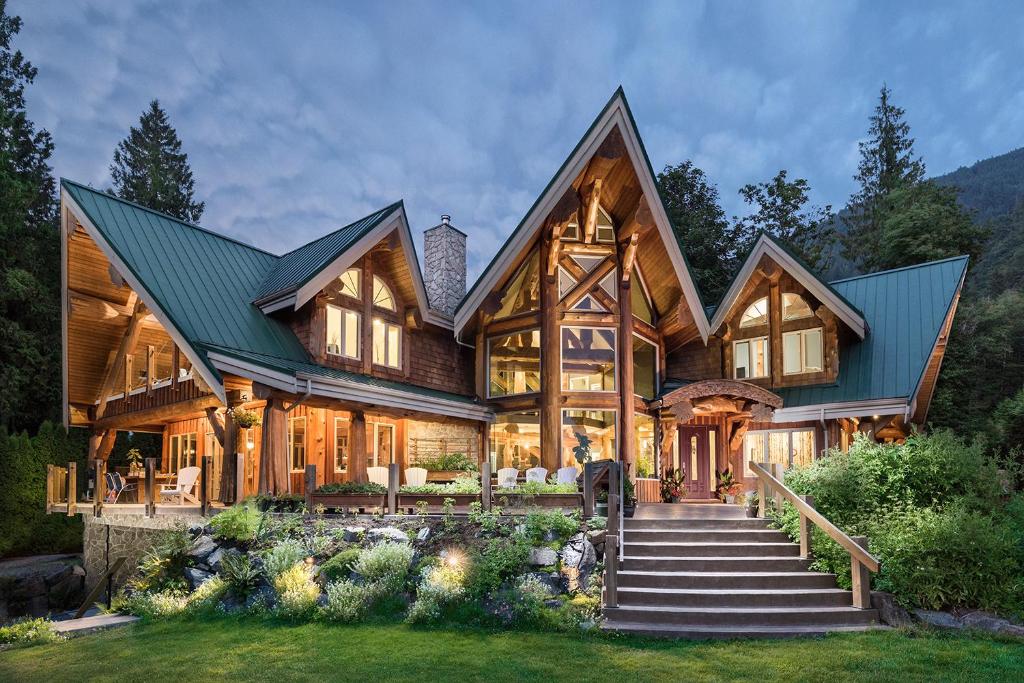 Casa de madera grande con techo verde en The Rockwell-Harrison Guest Lodge, en Harrison Hot Springs