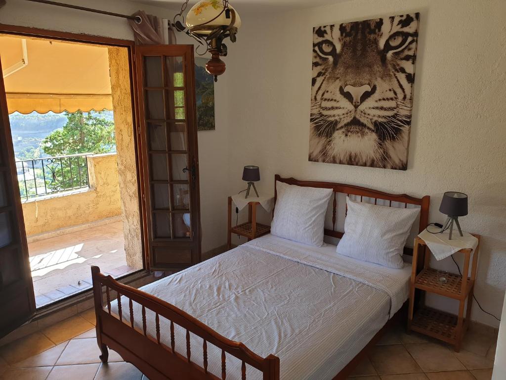 a bedroom with a bed and a picture of a tiger at Paradise in Peille