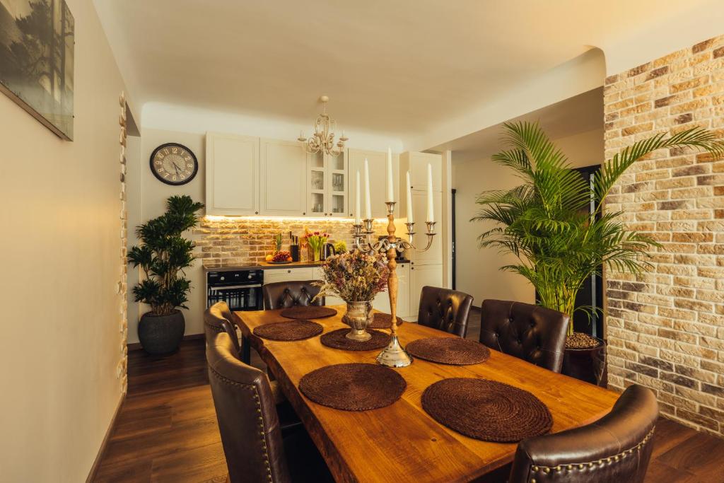 uma sala de jantar com uma mesa de madeira e cadeiras em Rezidence Liepas em Liepāja