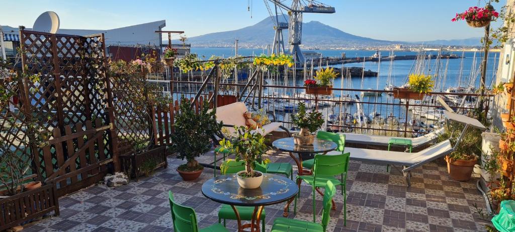 a patio with tables and chairs and a view of the water at Siriana open space in Castellammare di Stabia