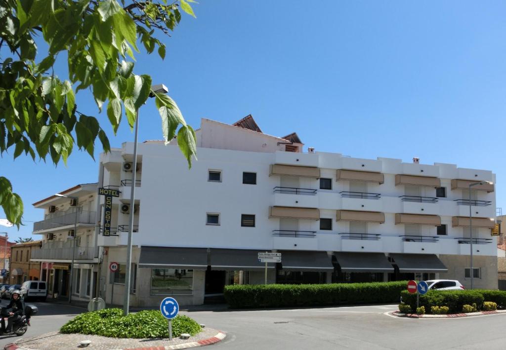 un edificio blanco al lado de una calle en Hotel Can Català en L'Escala