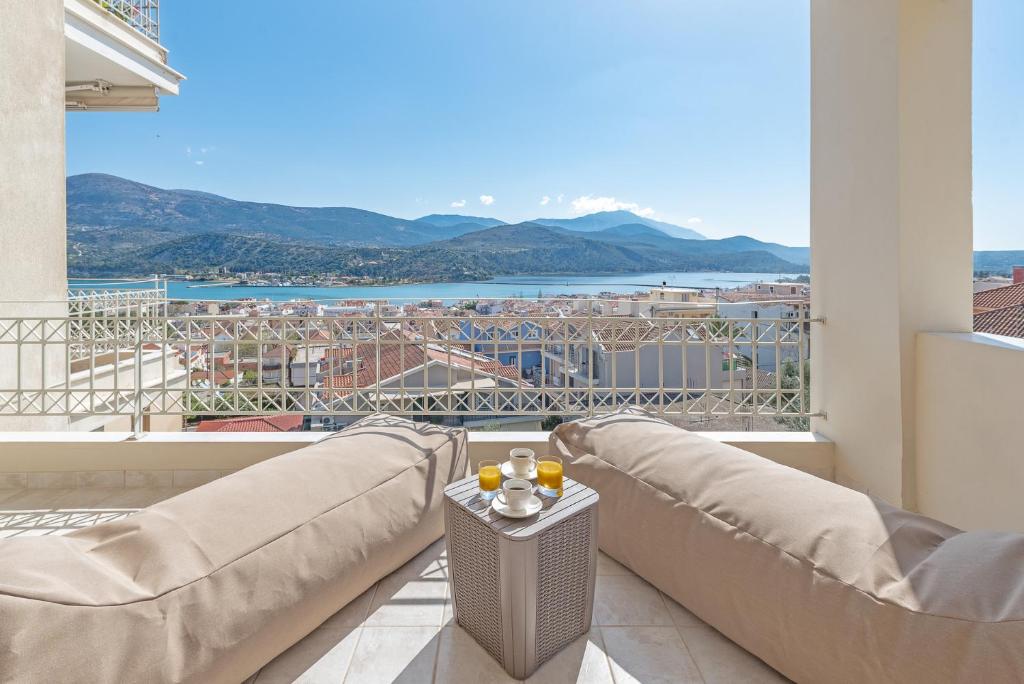 balcón con sofás y vistas a la ciudad en Alexandra's Cozy Sea View Apartment, en Argostoli