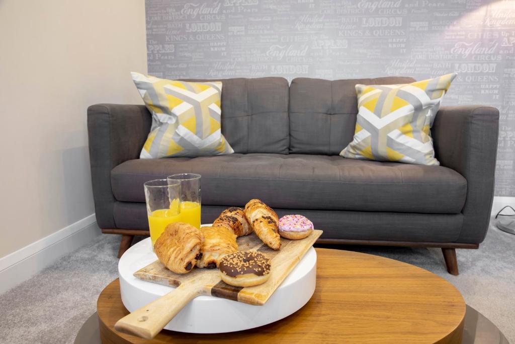 
a table topped with a plate of food next to a glass of orange juice at 2 Bedroom Town Centre Apartment in Cheltenham
