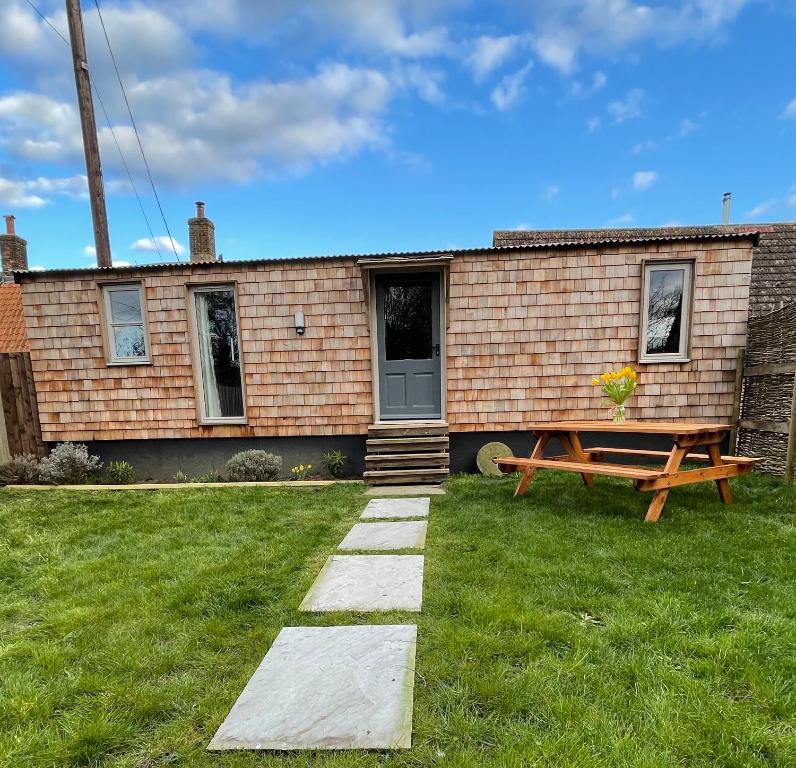 une maison avec une table de pique-nique devant elle dans l'établissement Keepers Cottage, à Ipswich