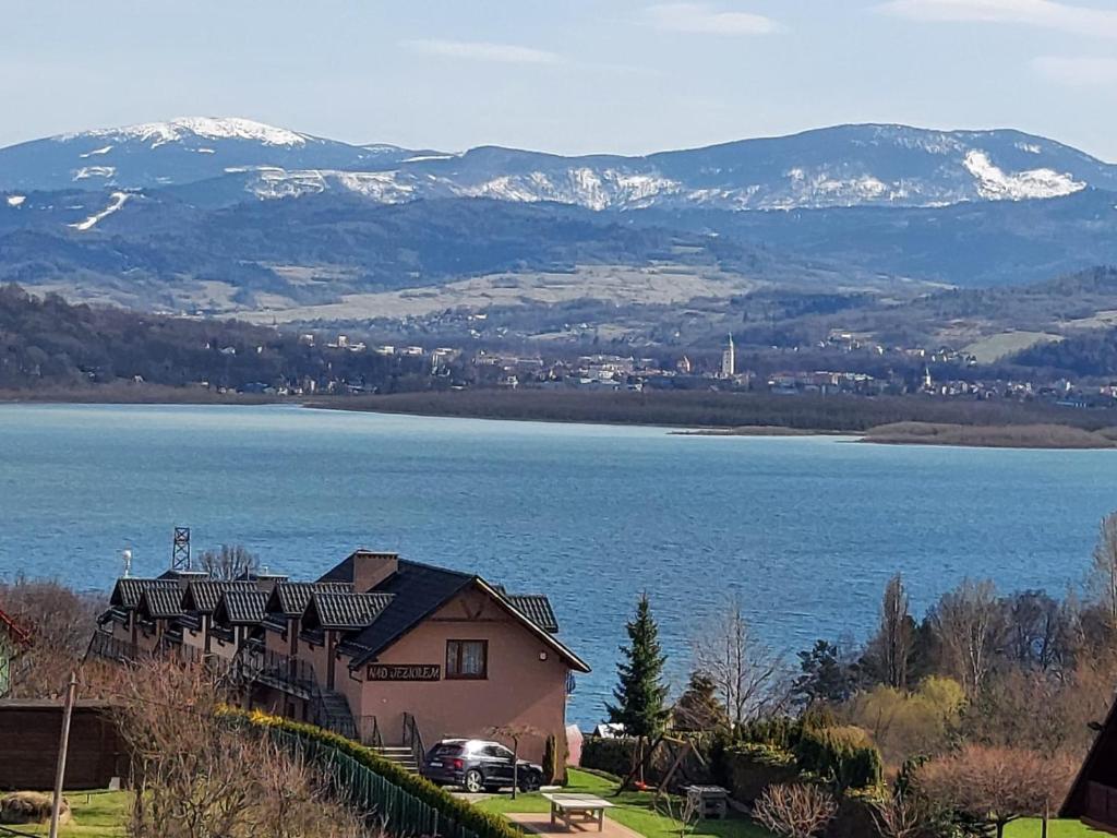 ジヴィエツにあるOśrodek Wypoczynkowy Nad Jezioremの湖と山の景色を望む家