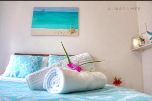 ein Schlafzimmer mit einem Bett und einem Handtuch darauf in der Unterkunft Suites Casa Azul-Vila do Abraão- conforto, limpeza, ótima localização in Abraão