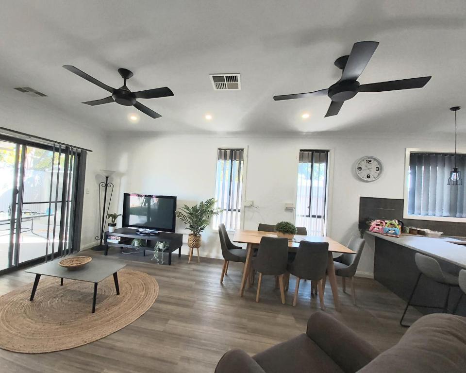 sala de estar con 2 ventiladores de techo y mesa en Lovely Modern 3br 2bth Beachside suburb Home en Largs