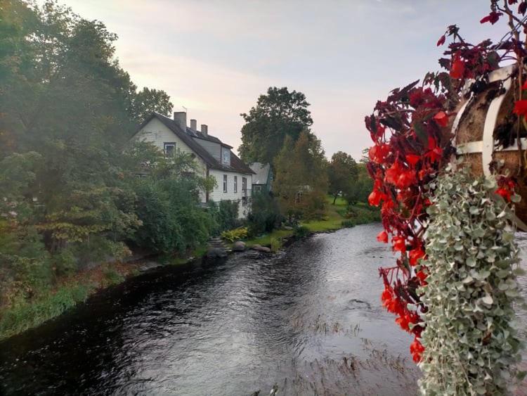 a river with red flowers on the side of a bridge at Lossi 8 Põltsamaa Erika in Põltsamaa