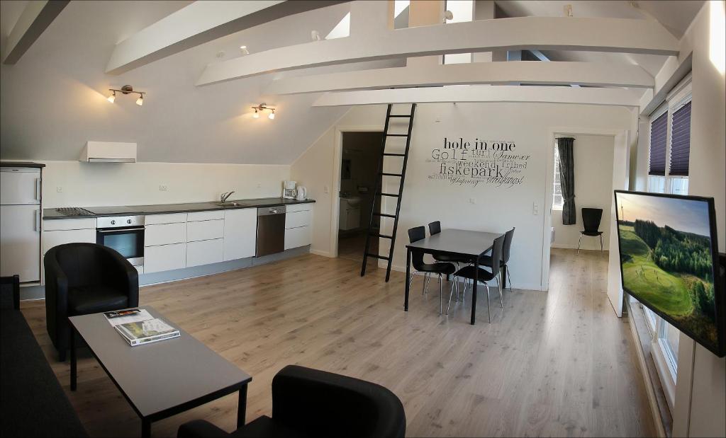 Habitación con mesa, sillas y cocina. en Volstrup Apartments en Stenild
