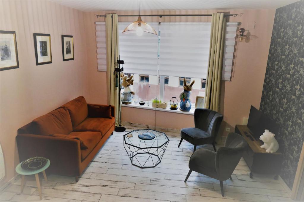 a living room with a couch and chairs and a window at Le gîte des sources: nature, randonnées, détente. in Oberbronn