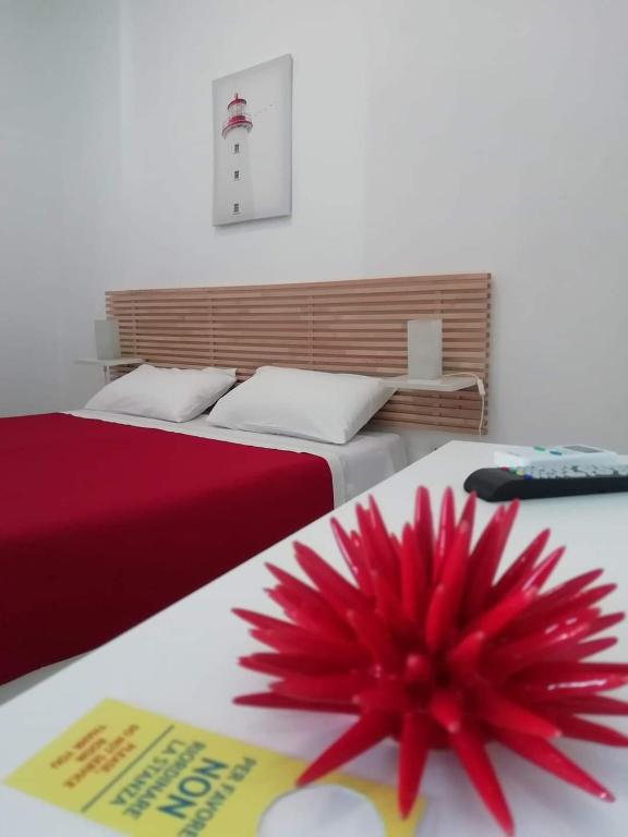 a red flower sitting on top of two beds at B&B Sole Mare Vento in Maruggio