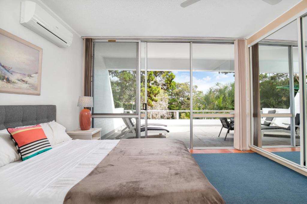 a bedroom with a bed and sliding glass doors at Noosa Views in Noosa Heads