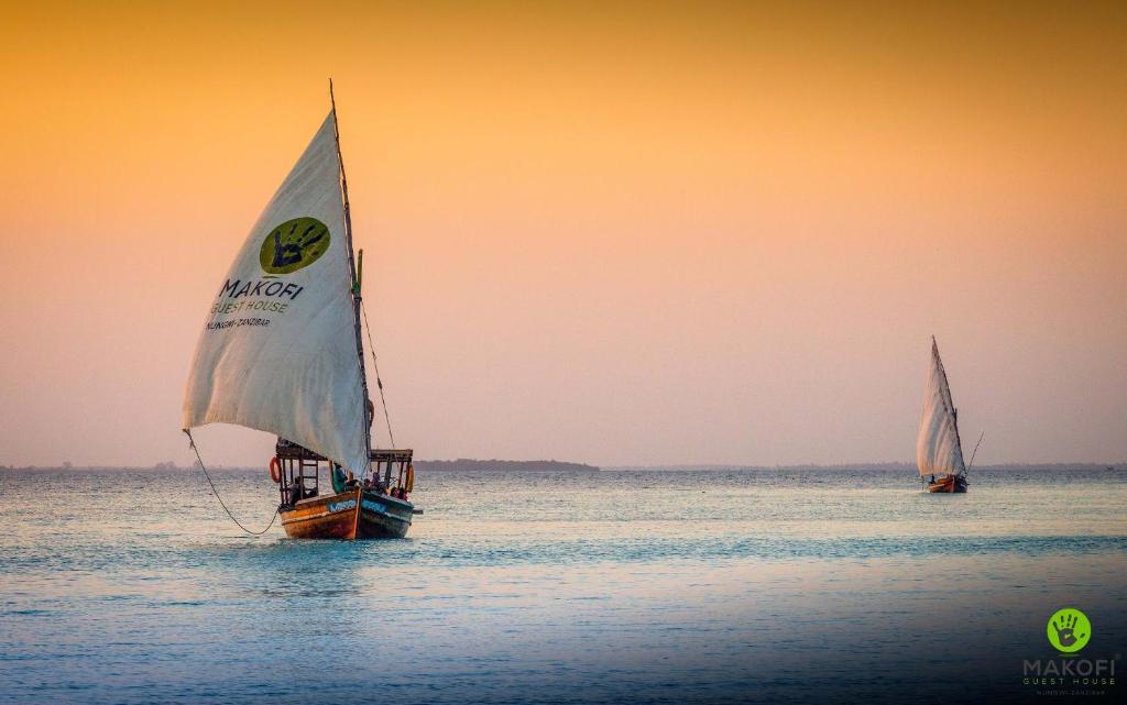 two sailboats on the water in the ocean at Makofi Guest House in Nungwi