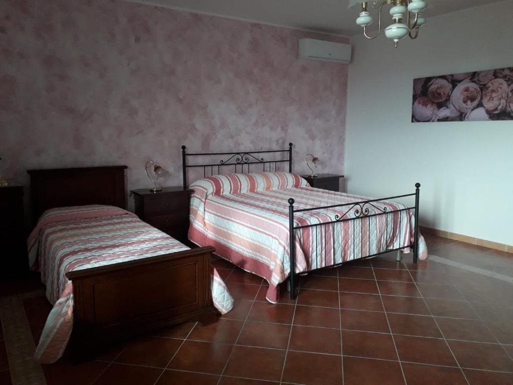 um quarto com 2 camas e piso em azulejo em Al dolce dormire em San Marco dei Cavoti