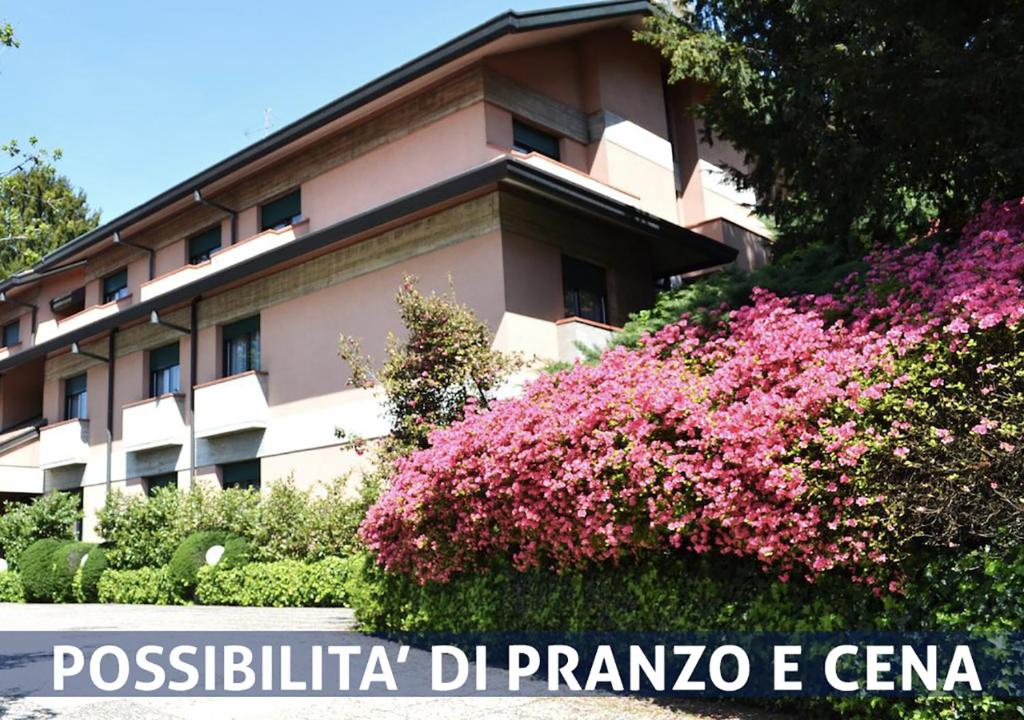 a building with pink flowers in front of it at Hotel Canturio in Cantù