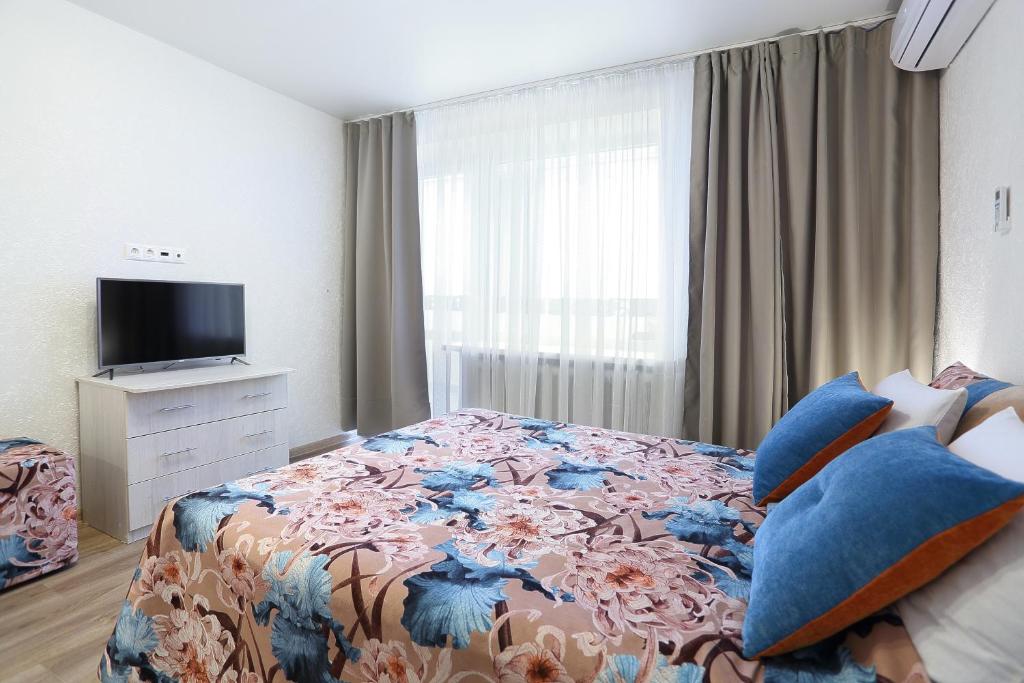 a bedroom with a large bed with a floral bedspread at flat-all 155 Bakunina двухкомнатная квартира до 9 мест рядом с ТРЦ "Галерея Чижова" in Voronezh