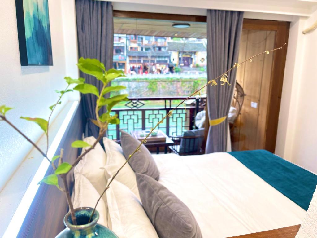 1 dormitorio con 1 cama y balcón en Bian Cheng Xing Zi Inn, en Fenghuang
