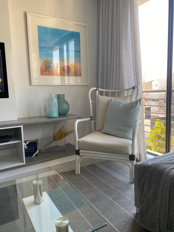 a living room with a chair and a window at One Hyde Park Sandton in Johannesburg