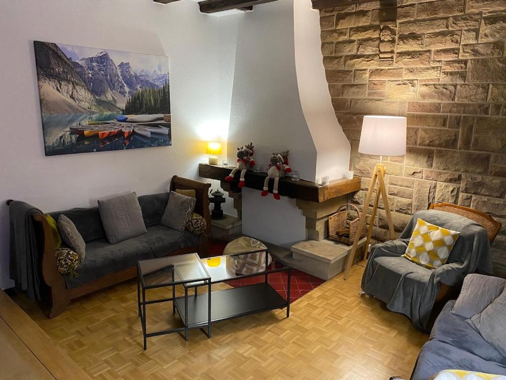 CHALET DE MANU في Sondernach: غرفة معيشة مع أريكة ومدفأة