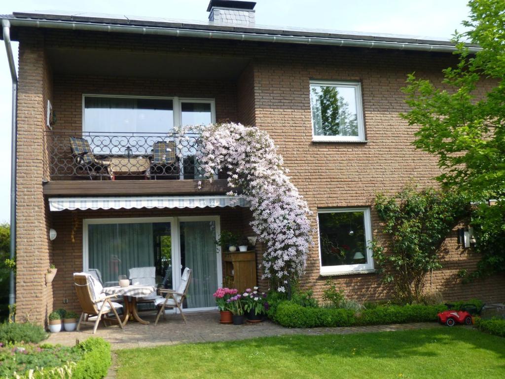 a house with a balcony with a table and flowers at Ferienwohnung Illerhues in Ascheberg
