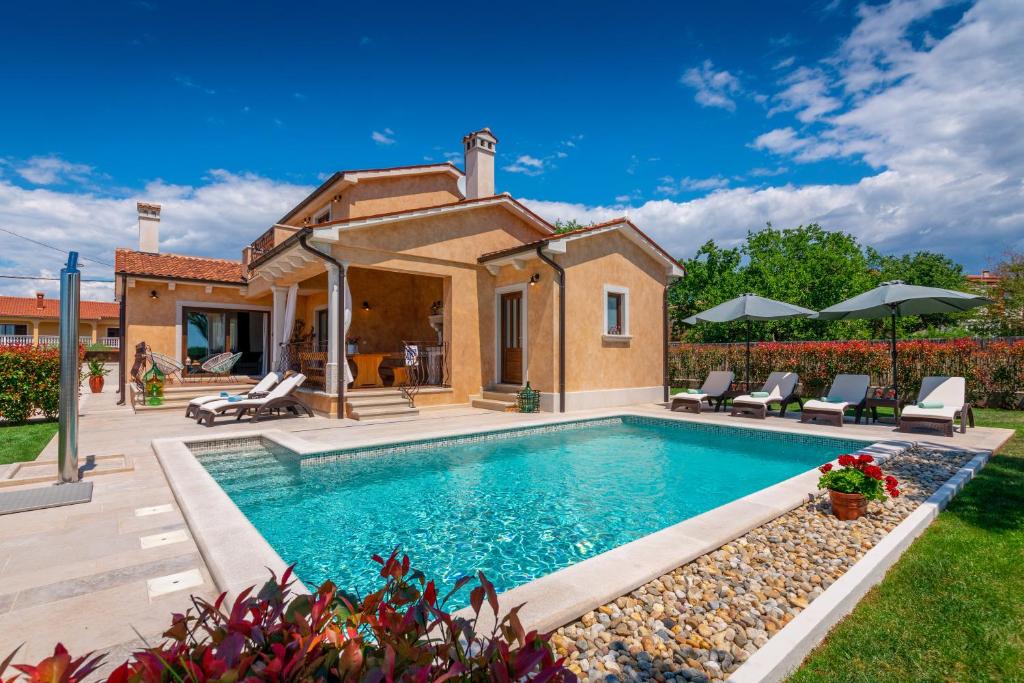 a swimming pool in a backyard with a house at Villa Rotonda in Vrsar
