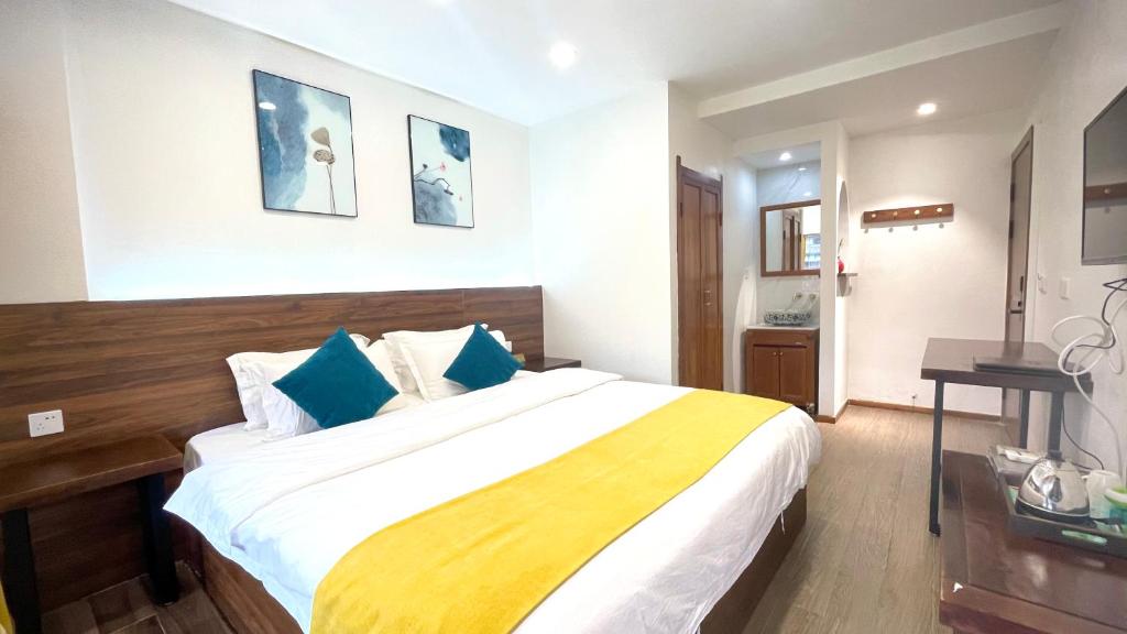a bedroom with a large bed with blue pillows at Bian Cheng Xing Zi Inn in Fenghuang County