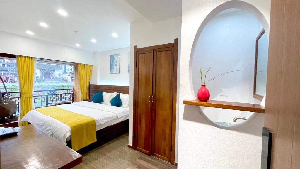 a hotel room with a bed and a window at Bian Cheng Xing Zi Inn in Fenghuang County