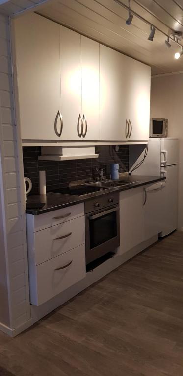 a kitchen with white cabinets and a stove at Dallavaraveien 4 in Vadsø
