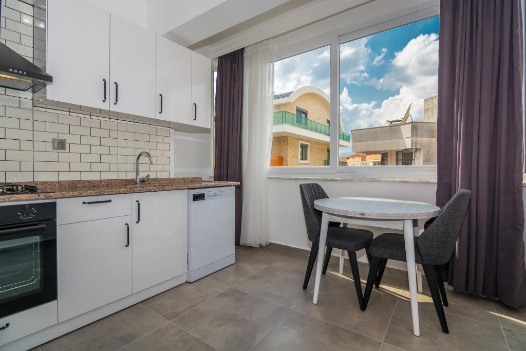 una cucina con tavolo, sedie e finestra di Seaside Apartments a Alanya