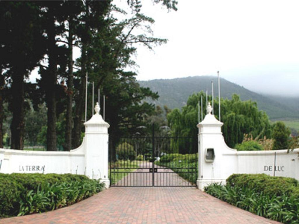 a white fence with a gate in a garden at La Terra de Luc in Franschhoek