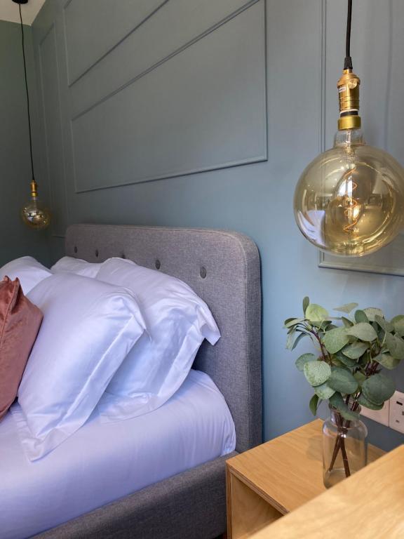 a bedroom with a bed with white sheets and a table at Lynwood Studio in Oban