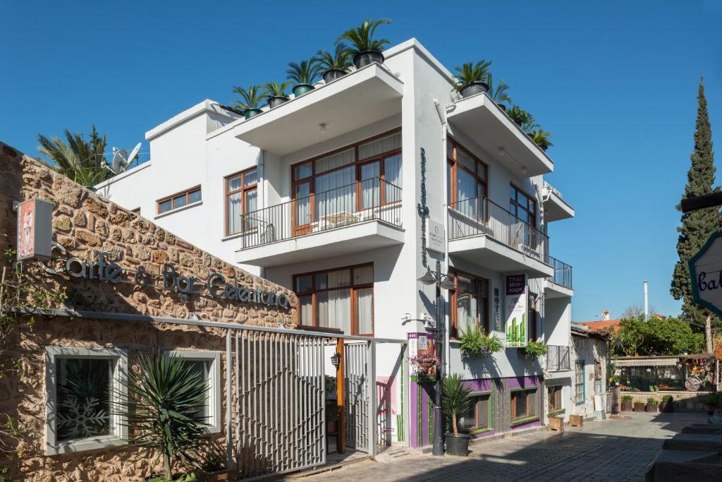 a white building with plants on the balconies at Delight Deluxe Port in Antalya