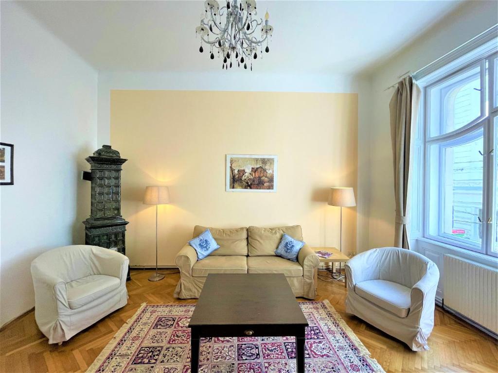 ein Wohnzimmer mit einem Sofa und 2 Stühlen in der Unterkunft King Apartments | contactless check-in in Wien