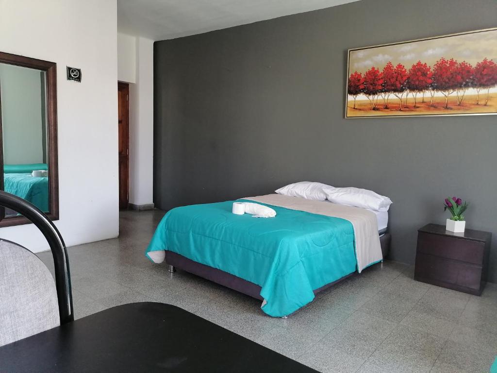um quarto com uma cama e um quadro na parede em Suite Trujillo em Trujillo
