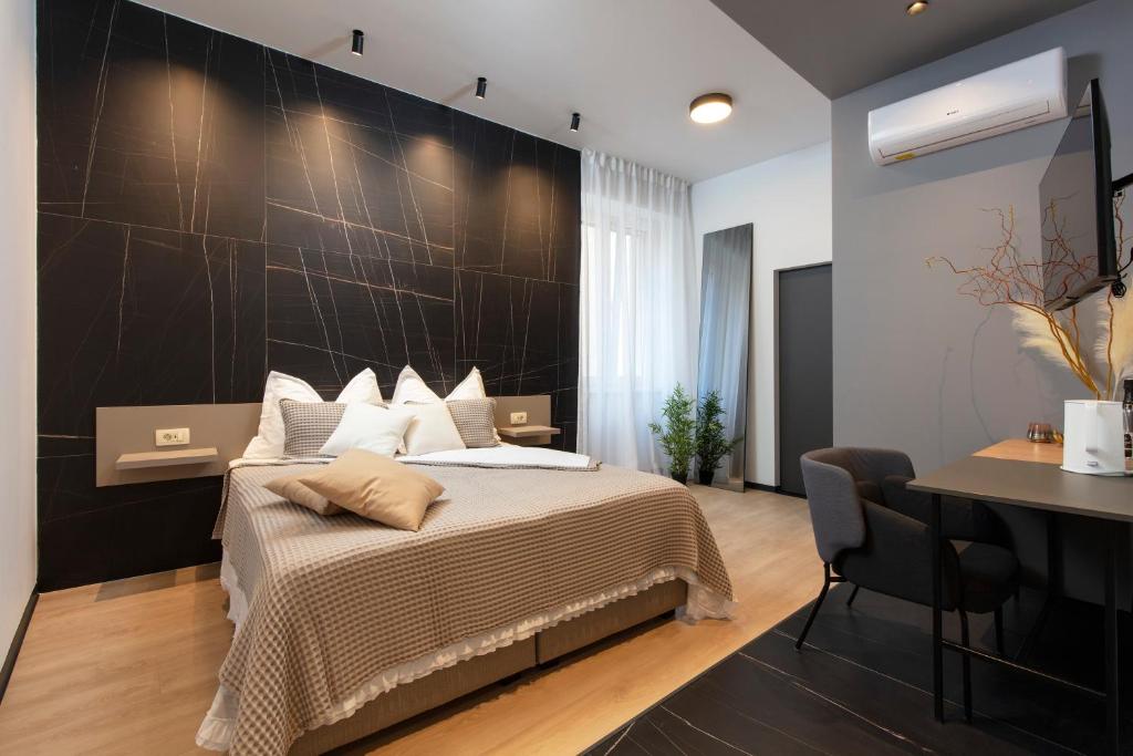 een slaapkamer met een bed met een zwarte muur bij Aborda Rooms in Split