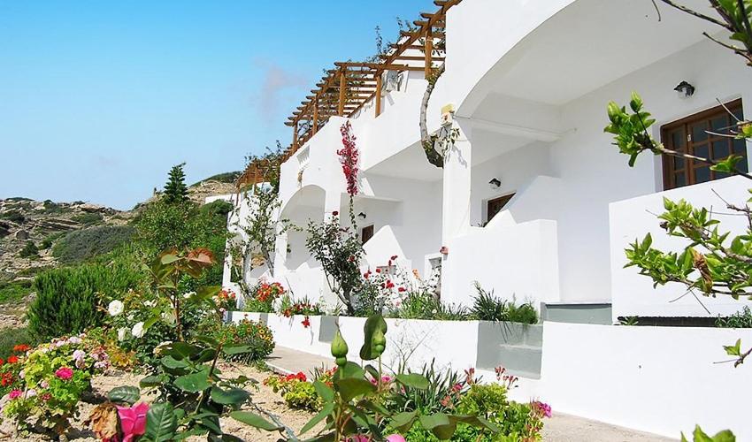 a white building with flowers on the side of it at Gliko Onoiro in Lefkos Karpathou