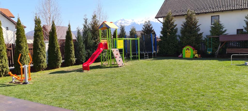 a playground with a slide in a yard at Pensiunea Dara in Râşnov