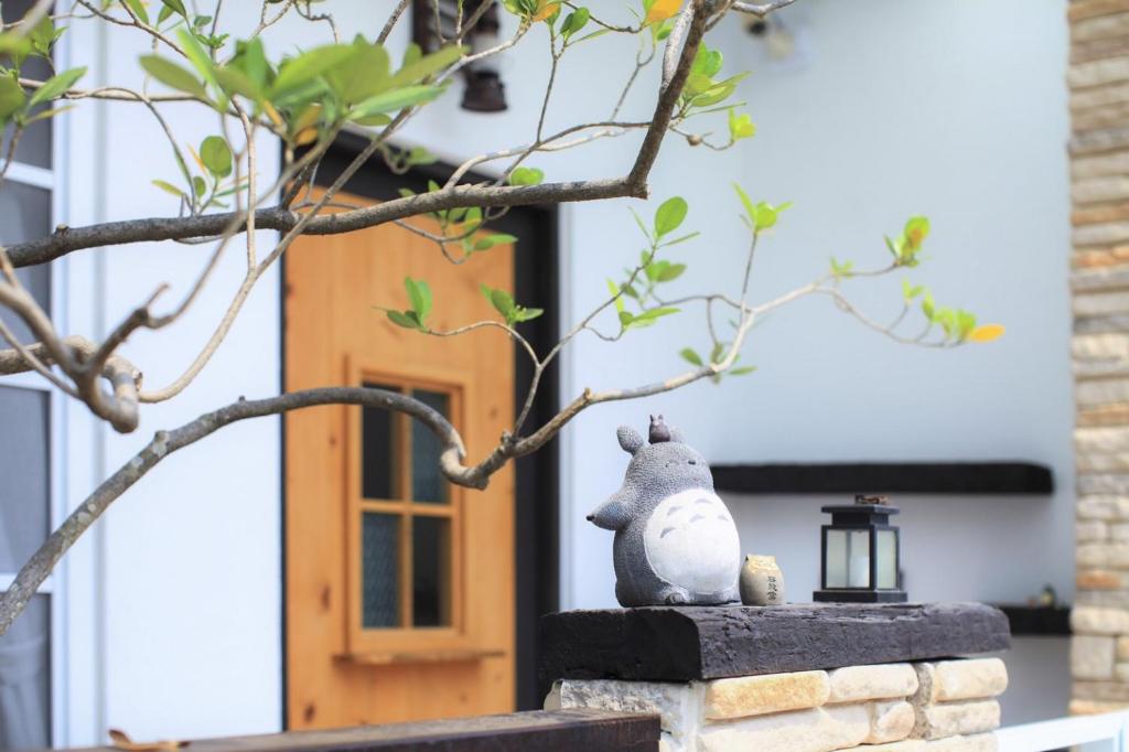 une statue d'un rat assis sur un mur devant une maison dans l'établissement 白鹿詩行旅, à Anping