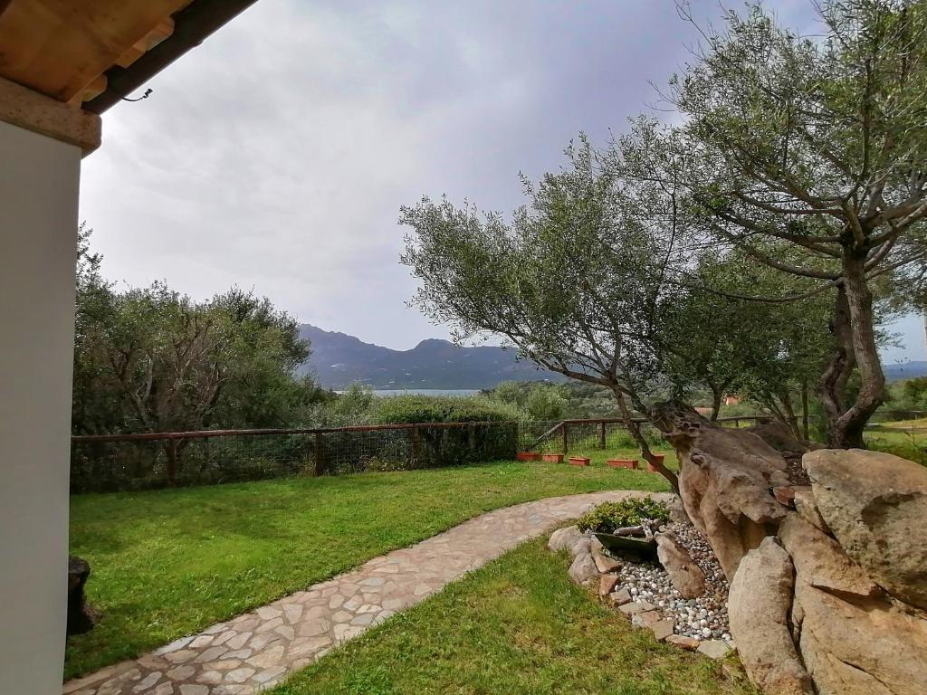 a garden with a stone path and a rock wall at B&B Su Terrabinu in Porto Rotondo