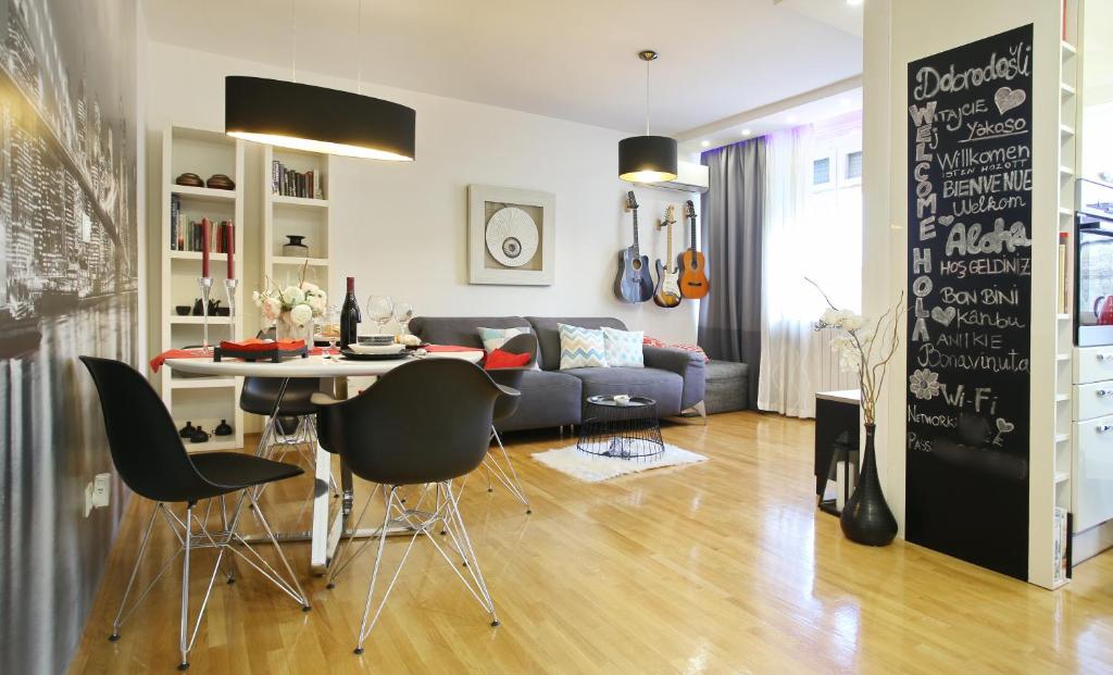 a living room with a couch and a table and chairs at Happy Guest Apartment Zagreb in Zagreb