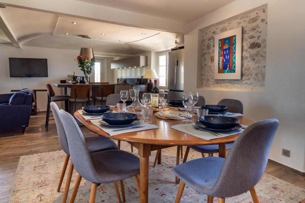 uma sala de jantar com uma mesa de madeira e cadeiras em Charmant appartement spacieux pour 6P vue mer vieil Antibes em Antibes