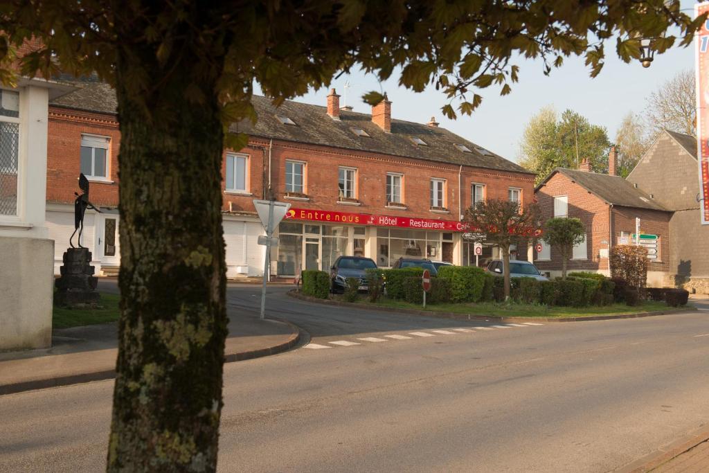 a street in a town with buildings and a tree at Entre Nous in Rozoy-sur-Serre