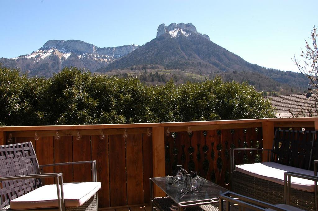 a balcony with a table and chairs and mountains at Le P'tit Chalet de la Fressine in Alex