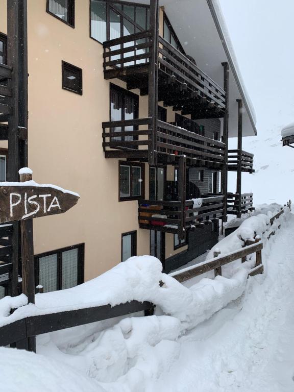 a building covered in snow with a sign in front of it at Stunning view in Breuil-Cervinia