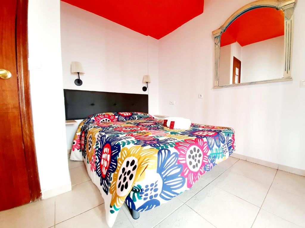 a bedroom with a bed with a colorful comforter at Arc House Ribera Only Adults in Córdoba