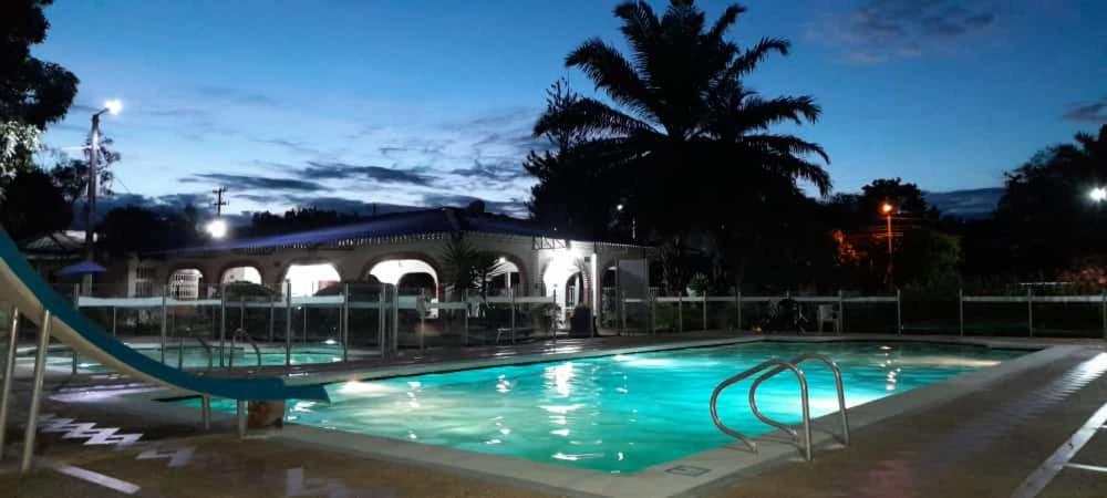 a swimming pool at night with a slide at Club Bella Suiza - Carlos Ossa Escobar in Villavicencio