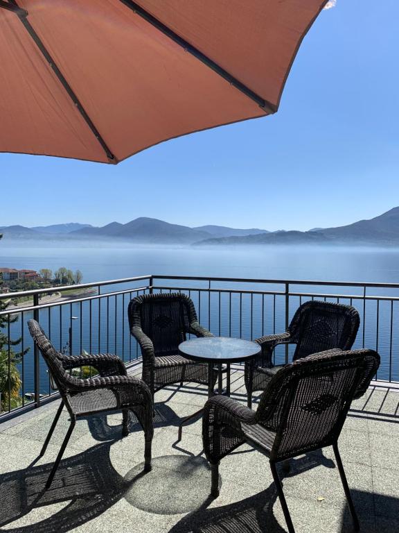 einen Tisch und Stühle auf einem Balkon mit Blick auf das Wasser in der Unterkunft Villa Angelina Guest House in Cannero Riviera